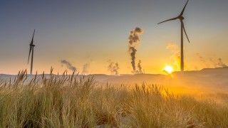 Widok na turbiny wiatrowe przy wydmach i zachód słońca