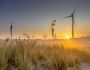 Widok na turbiny wiatrowe przy wydmach i zachód słońca