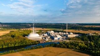 Niemiecka elektrownia jądrowa w Neckarwestheim w Niemczech na tle pól i rzeki.