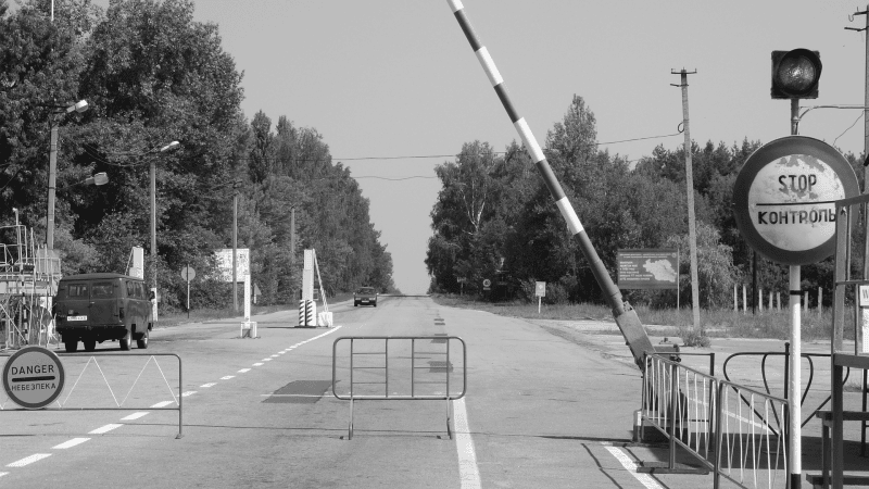 Brama wjazdowa ze szlabanem i znakami Stop i Danger po angielsku i rosyjsku