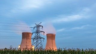 Reaktory jądrowe na tle łąki.