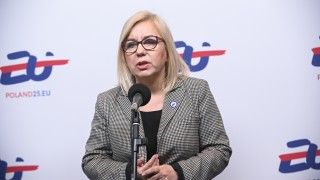 Ministra stoi na tle ścianki z logo polskiej prezydencji i napisem POLAND25.EU, mówi do mikrofonu