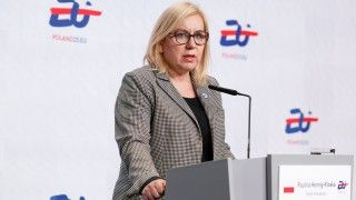 Ministra stoi przy mównicy na tle ścianki z logo polskiej prezydencji i napisem POLAND25.EU, mówi do mikrofonu