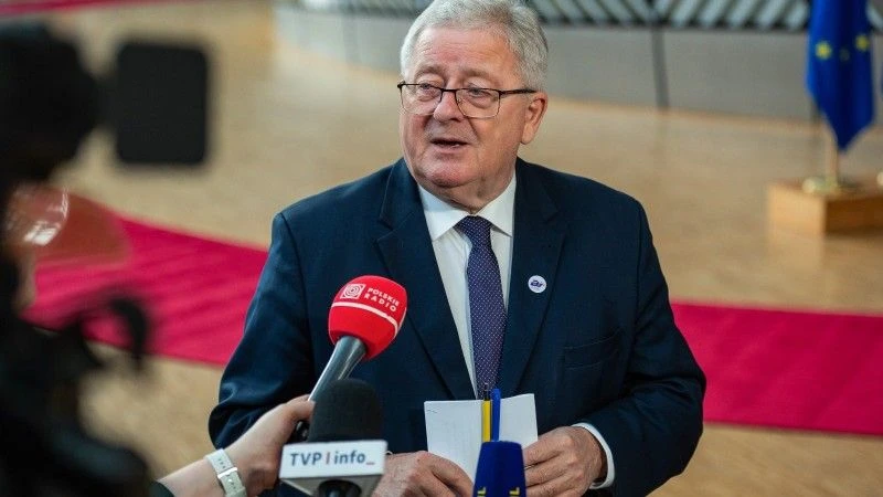 Minister mówi do mikrofonów kilku mediów