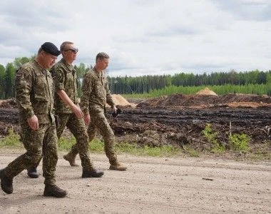 Prezydent Łotwy Edgars Rinkēvičs (w środku) podczas wizytownia poligonu wojskowego „Sēlija”.