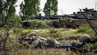 Żołnierze 21. Brygady Strzelców Podhalańskich na ćwiczeniu „Rozsądny Gronostaj 25”. W tle czołgi podstawowe M1A1FEP Abrams z 1. Warszawskiej Brygady Pancernej oraz kołowe transportery opancerzone Rosomak z wieżą ZSSW-30 z 21. BSP.