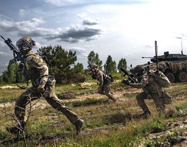 Żołnierze 21. Brygady Strzelców Podhalańskich na ćwiczeniu „Rozsądny Gronostaj 25”. W tle kołowy transporter opancerzony Rosomak z wieżą ZSSW-30.