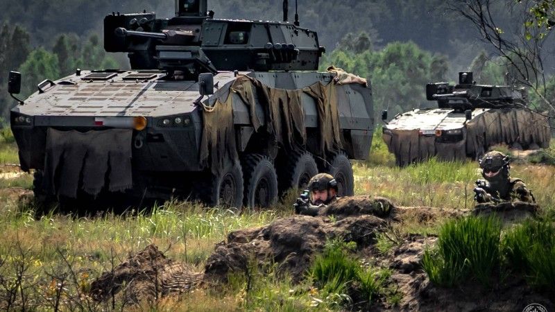 Żołnierze 21. Brygady Strzelców Podhalańskich na ćwiczeniu „Rozsądny Gronostaj 25”. W tle kołowe transportery opancerzone Rosomak.