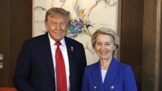 Politycy stoją obok siebie na tle obrazu