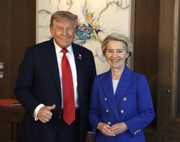 Politycy stoją obok siebie na tle obrazu