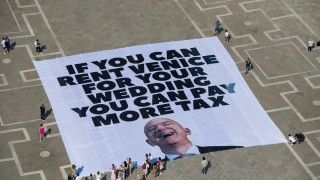 Transparent na placu św. Marka z napisem: if you can rent Venice for your wedding you can pay more tax i podobizną Bezosa