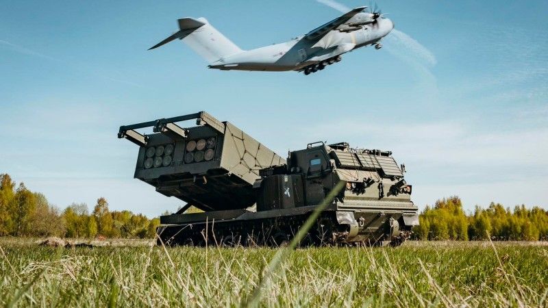 Wieloprowadnicowa wyrzutnia rakiet M270B1 należąca do brytyjskiego 3. Pułku Królewskiej Artylerii Konnej. W tle samolot transportowy Airbus A400M.