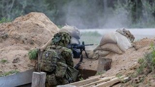 Estoński żołnierz z uniwersalnym karabinem maszynowym IWI Negev.