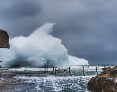 wysokie fale uderzają o skały na brzegu