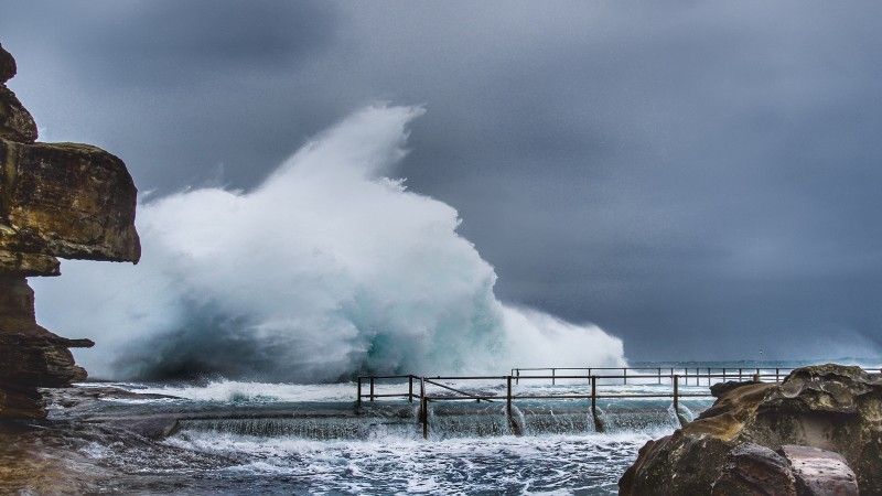wysokie fale uderzają o skały na brzegu