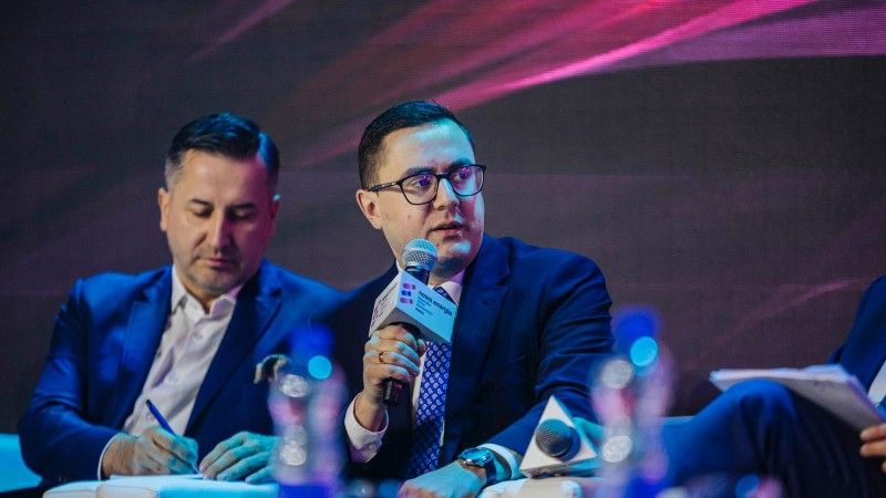 minister przemawia do mikrofonu na panelu dyskusyjnym