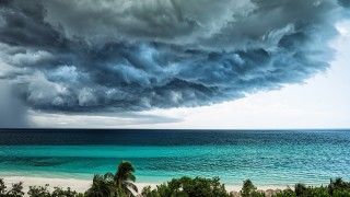 ciemne chmury zbierają się nad rajską plażą nad oceanem