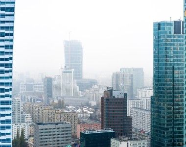 Widok na wieżowce Warszawy w mglisty poranek, miasto jest pokryte smogiem