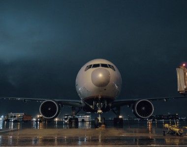 Samolot stojący na płycie lotniska w czasie burzy, nawierzchnia jest mokra od deszczu