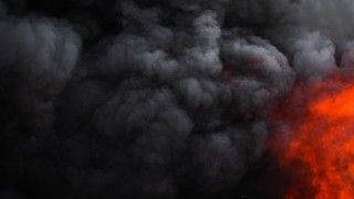 Czarny dym i ogień zasłaniające niebo.