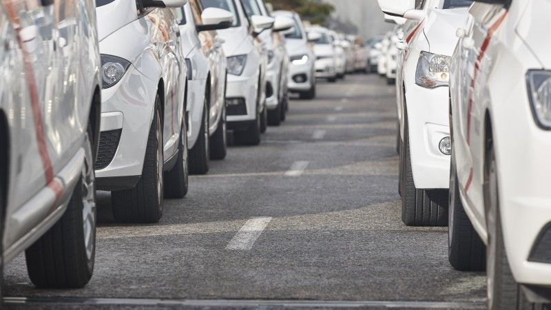 Białe samochody stojące na jezdni.