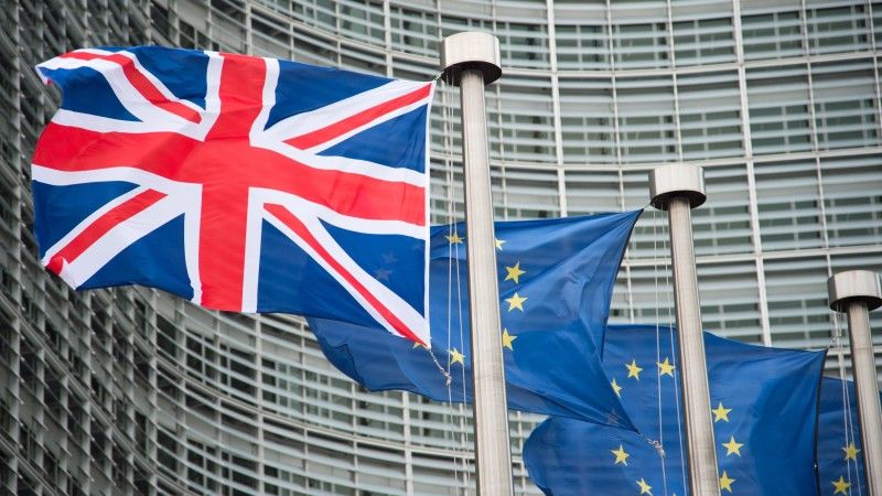 Flagi Wielkiej Brytanii i Unii Europejskiej na tle budynku KE w Brukseli.