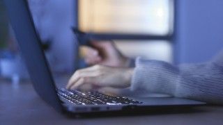 Kobiece dłonie na klawiaturze komputera.