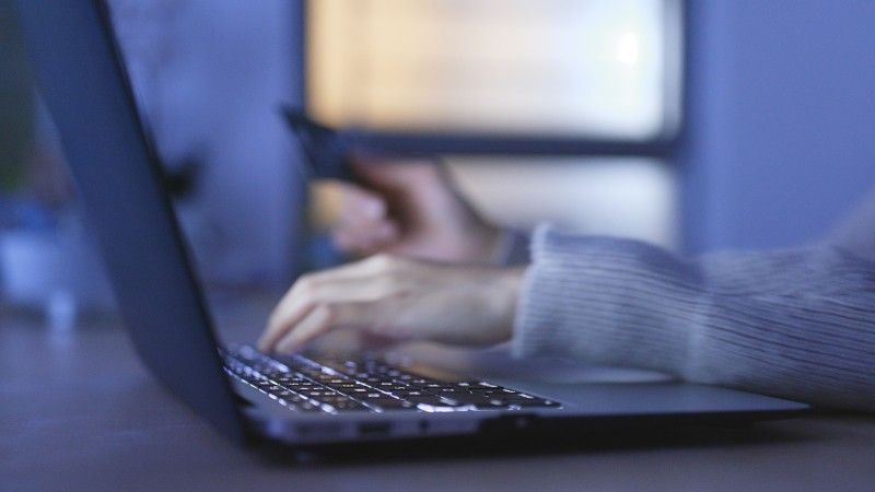 Kobiece dłonie na klawiaturze komputera.