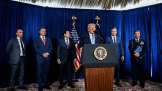 Prezydent USA Donald Trump przemawiający do mikrofonu w obecności amerykańskich władz.