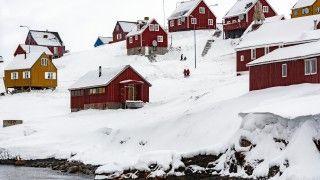 Czerwone domy na Grenlandii w śniegu.