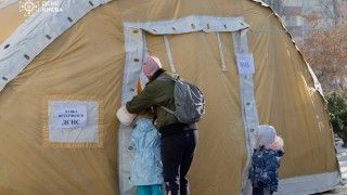 Kobieta z dwojgiem dzieci wchodzi do ogrzewanego namiotu w Kijowie po nocnych atakach Rosjan, w wyniku których stolica została w znacznym stopniu pozbawiona ogrzewania.