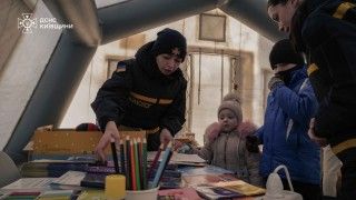 Ukraińskie dzieci ogrzewające się w namiocie po zmasowanych atakach Rosji na Kijów.