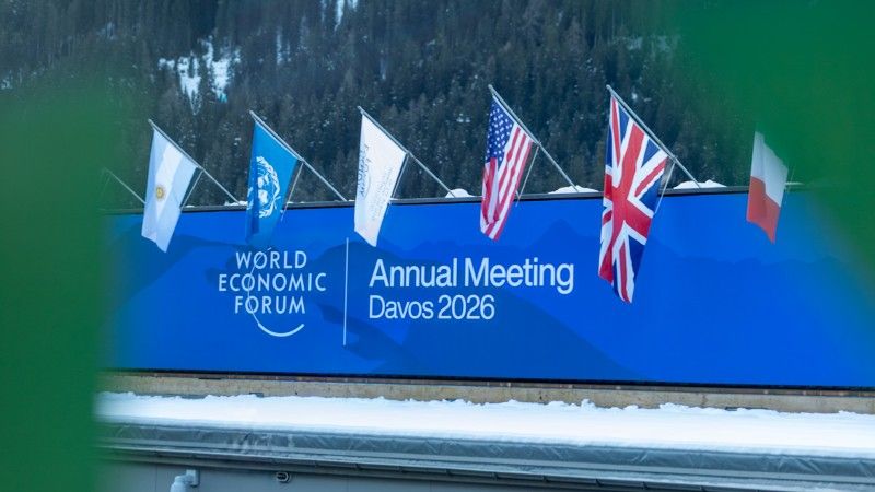 baner z napisem world economic forum annual meeting davos 2026 i flagami ONZ i kilku państw: Argentyny, USA, UK