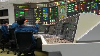 stacja kontrolna w elektrowni, inżynierowie siedzą przy monitorach