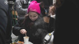 Dziewczynka ogrzewająca się w specjalnym punkcie w Kijowie.