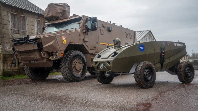 Bezzałogowiec Hermione UGV podczas ćwiczeń z francuskimi żołnierzami. Obok niego francuski kołowy transporter opancerzony VBMR Griffon.