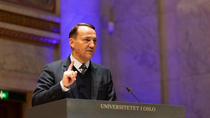 Radosław Sikorski przemawia zza mównicy z napisem Universitetet I Oslo