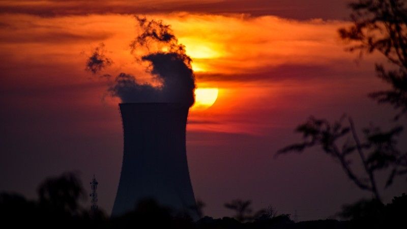 Chłodnia kominowa elektrowni jądrowej na tle zachodzącego słońca.