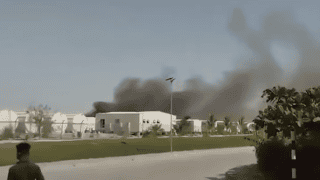Nagranie dymu unoszącego się zza budynków po ataku dronów na port w Omanie