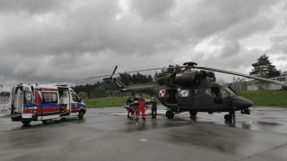 Moment przekazania osoby poszkodowanej z wojskowego Sokoła do cywilnej karetki