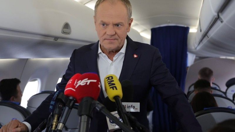 Premier Polski Donald Tusk w czasie konferencji prasowej na pokładzie samolotu.