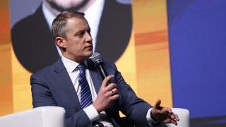 Kacper Kostrzewa mówi do mikrofonu na scenie