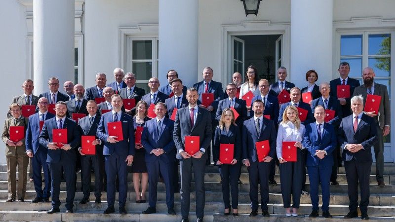 członkowie rady stoją przed budynkiem, pozują do zdjęcia