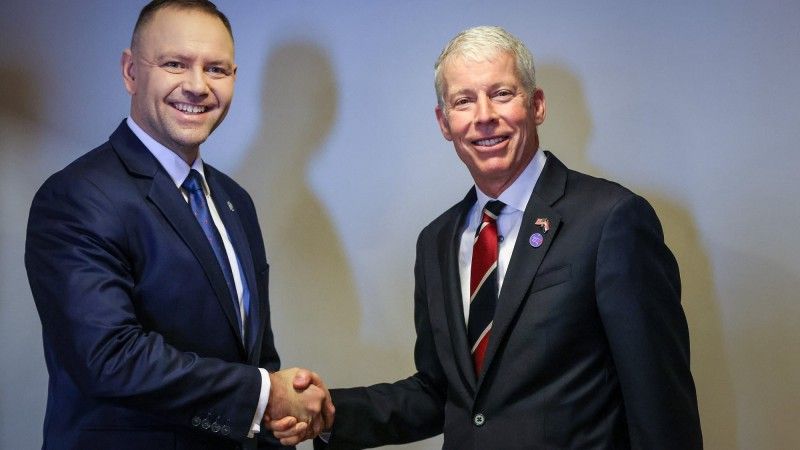 Mężczyźni ściskają sobie ręce i pozują do zdjęcia