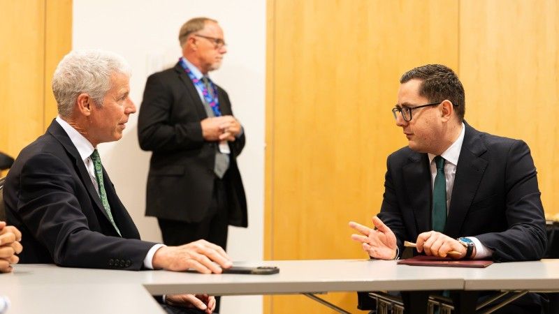 Politycy Miłosz Motyka i Chris Wright w trakcie rozmowy przy stole w czasie XI Szczytu oraz Forum Biznesu Inicjatywy Trójmorza.