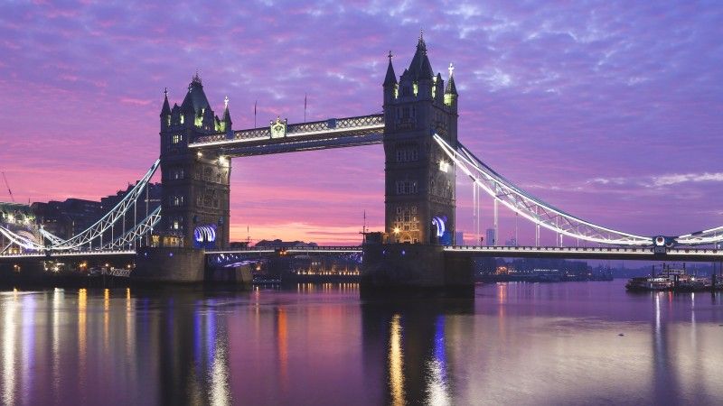 Oświetlony most zwodzony w Londynie Tower Bridge o zachodzie słońca.
