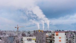 Dym z kominów unoszący się nad blokami zimą.