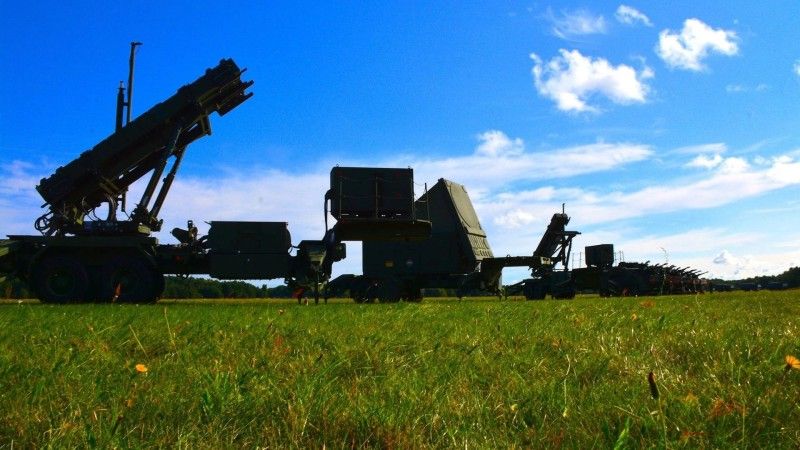 Elements of a Polish Patriot battery — two launchers and a fire-control radar — with elements of the Pilica system in the background.