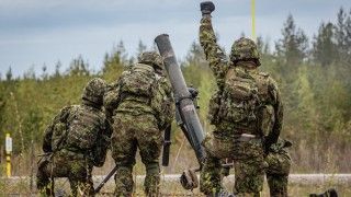 Estonian soldiers in camouflage operate a mortar during Exercise Spring Storm 26 in a forest training area.