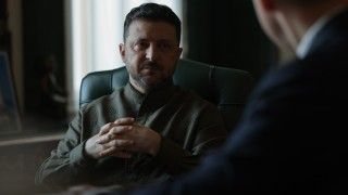 prezydent siedzi w cieniu, ręce ma złożone